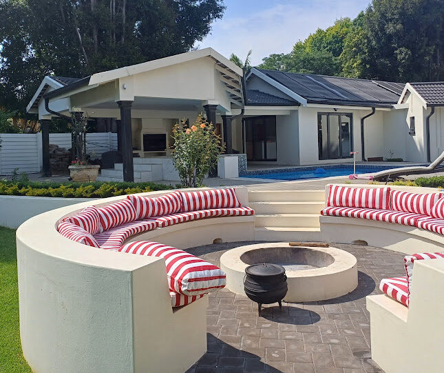 Circular sunken fire pit with built-in seating and paved outdoor entertainment area