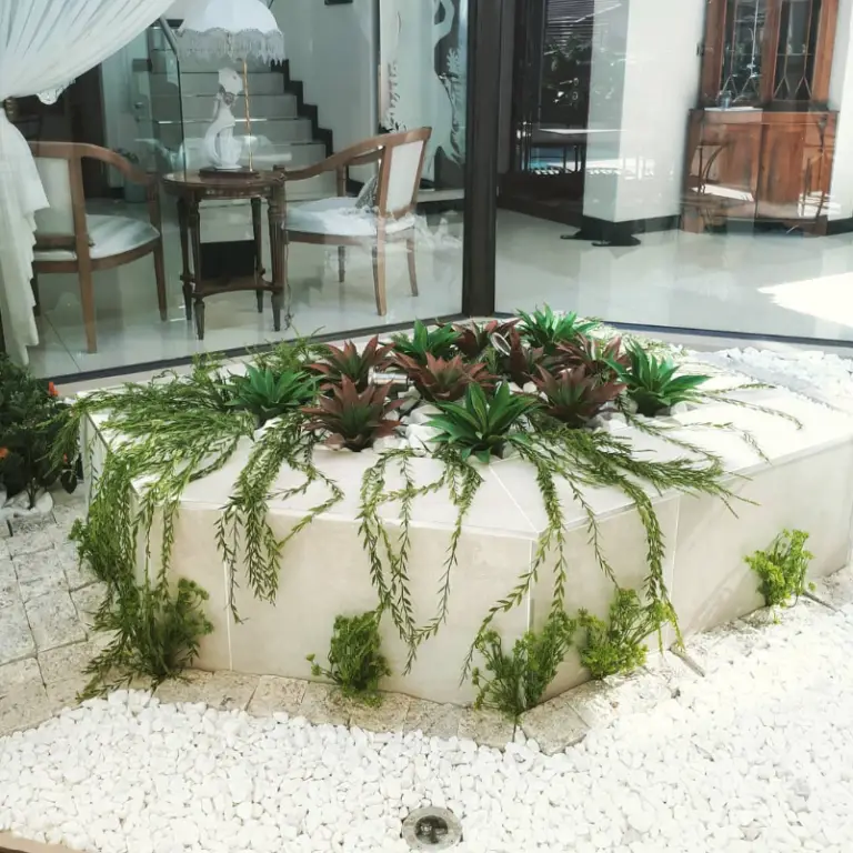 Contemporary atrium with artificial planting, decorative marble stone and integrated garden lighting